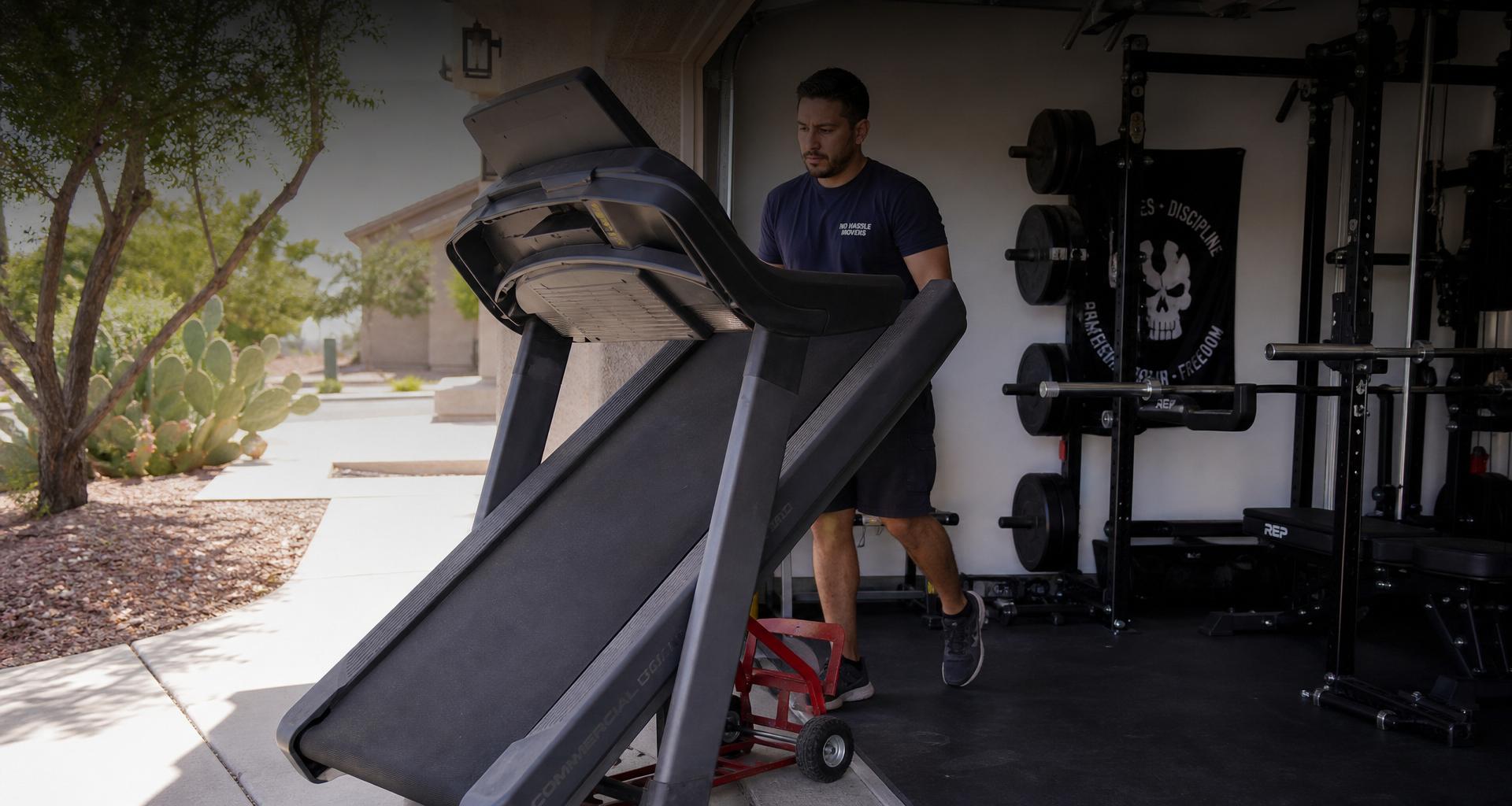 No Hassle Movers crew moving a treadmill out of a Tucson home garage gym